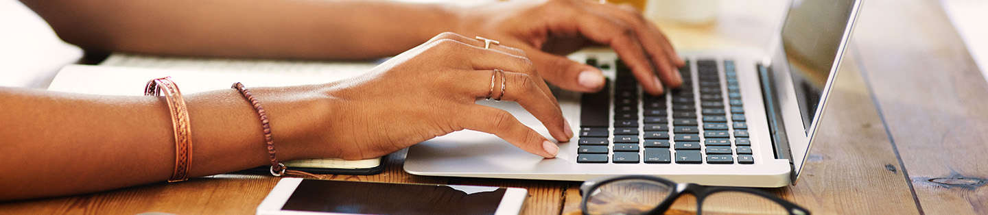 womens hands typing on her laptop
